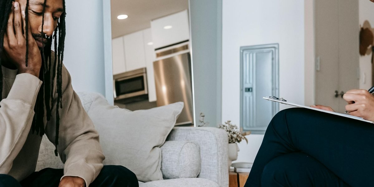 A therapist and client engaging in a calm and supportive conversation during a therapy session.