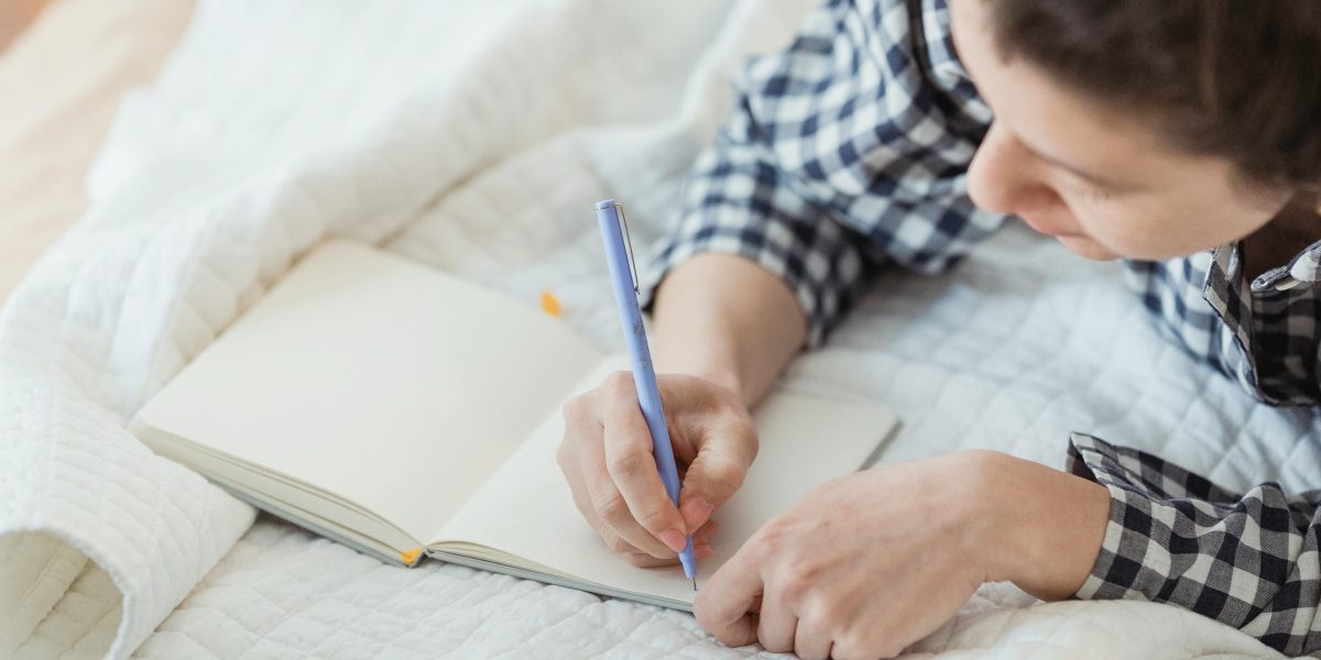 A person engaged in journaling, reflecting on their thoughts and feelings in a peaceful setting.