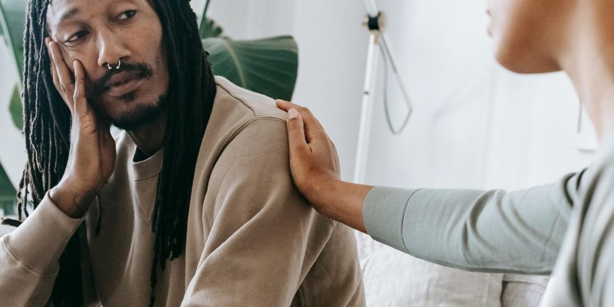 An individual engaged in a supportive conversation with a professional, seeking help for emotional challenges.