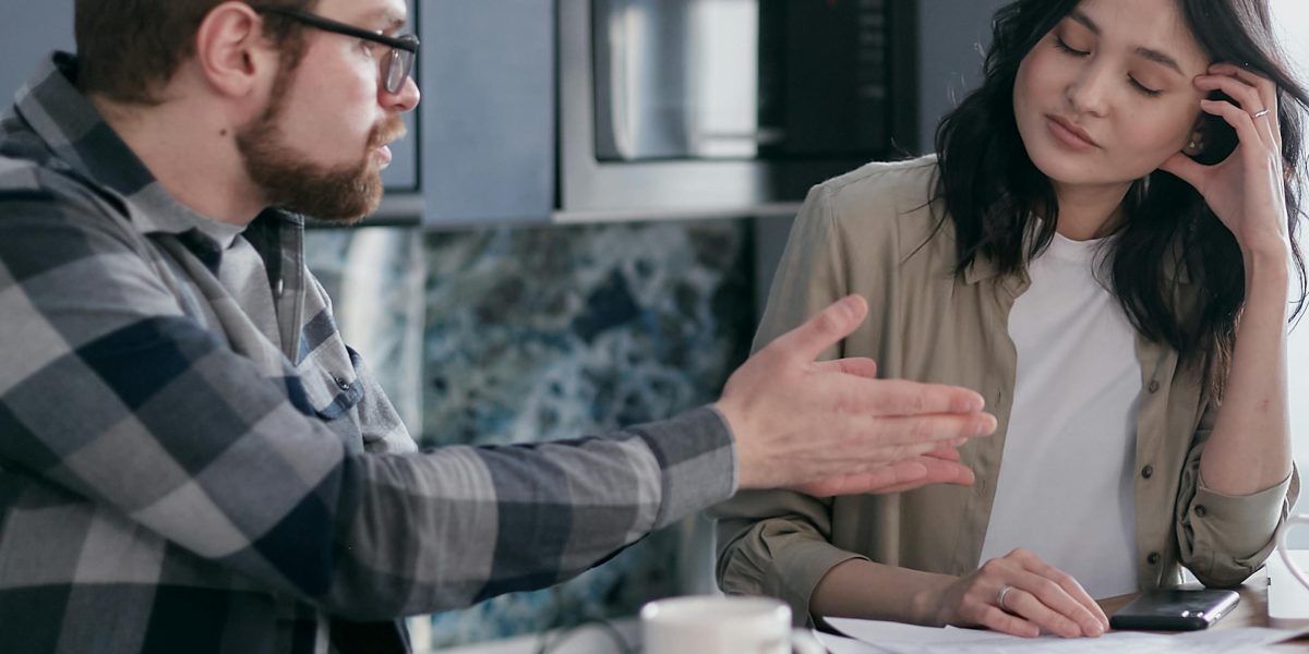 A couple engaged in a serious conversation, highlighting the emotional impact of unresolved relationship anxiety.