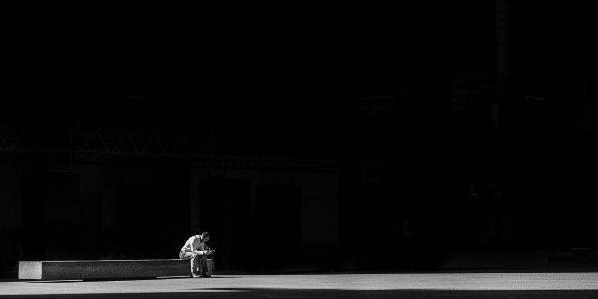 A person feeling overwhelmed and burdened, symbolizing the weight of anxiety.