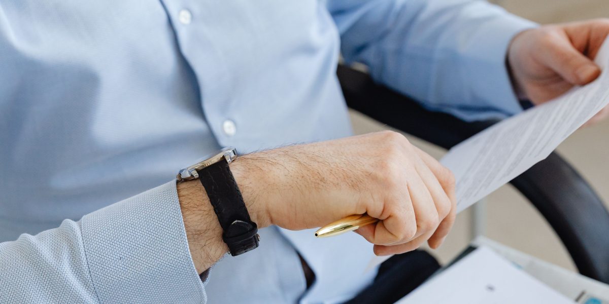 A person carefully examining documents, representing the thoroughness required when reading therapist profiles.