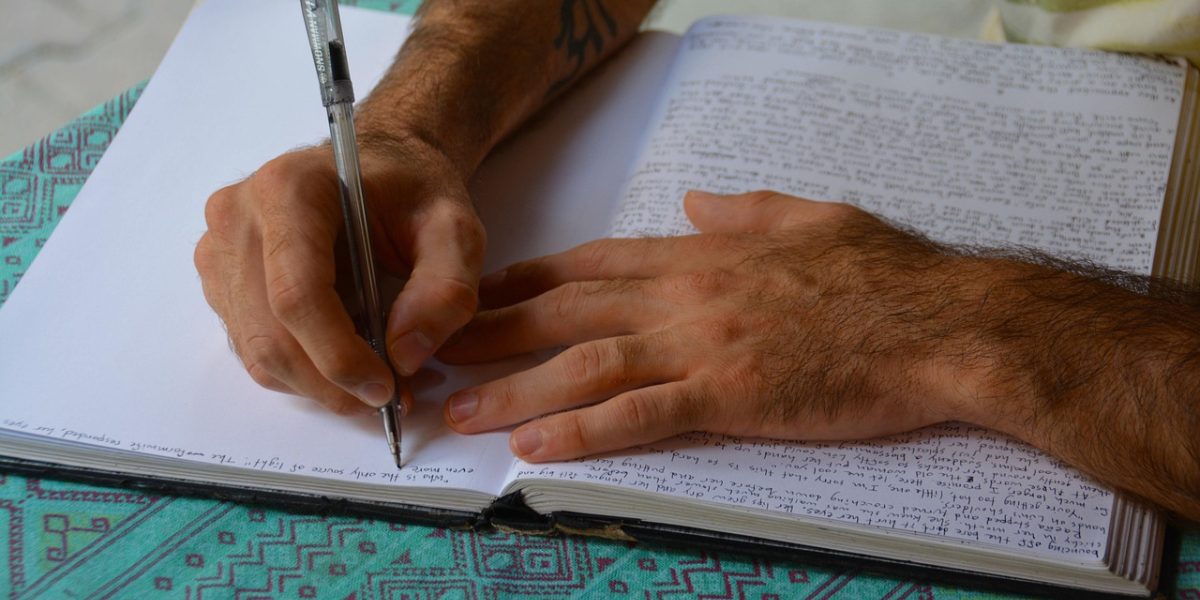 A person writing down thoughts and feelings, preparing for a discussion about their mental well-being.