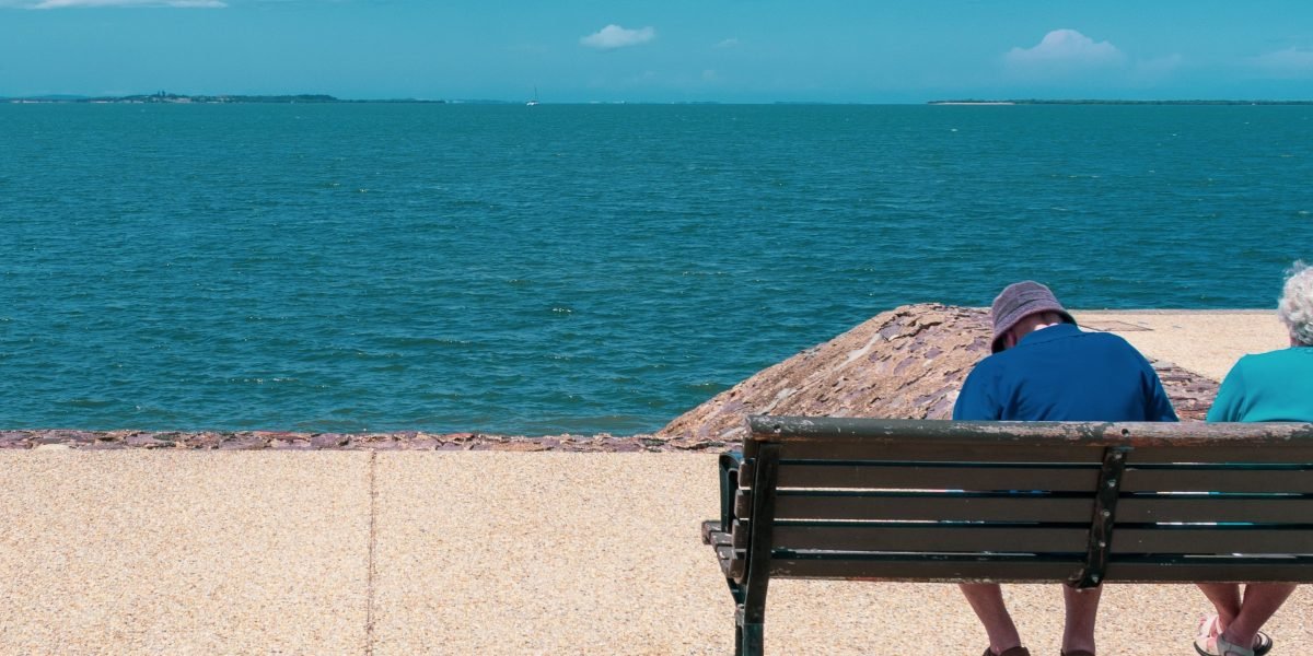 A couple sits apart, symbolizing emotional distance and being 'stuck' in a relationship.