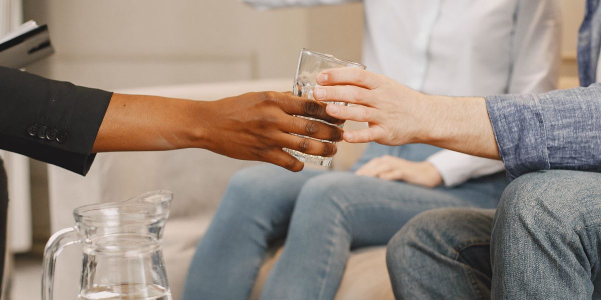 A couple sitting with a therapist in a session, engaging in open conversation.