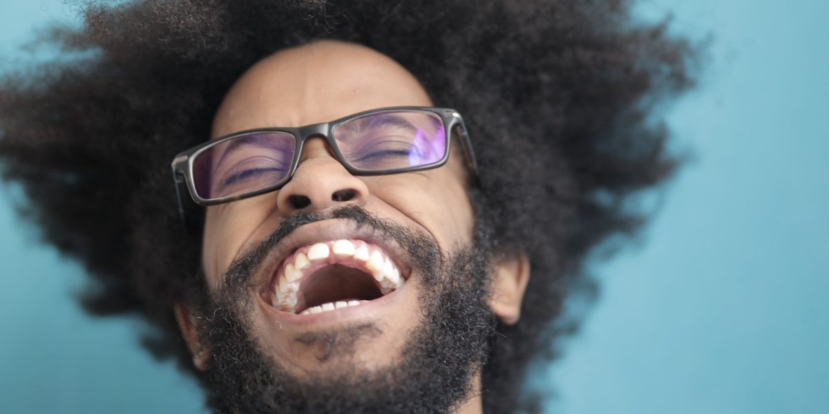 A person laughing, experiencing a moment of relief and calm.
