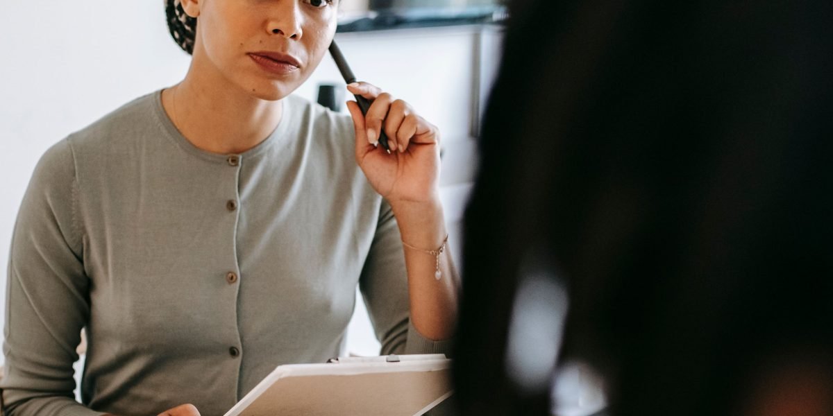 A therapist actively listening to a client in a calm, supportive environment, emphasizing the importance of the therapeutic relationship.