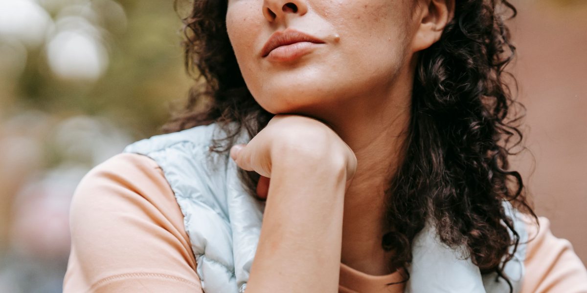 A person standing before a symbolic barrier or challenge, reflecting on the difficulty of accessing care.