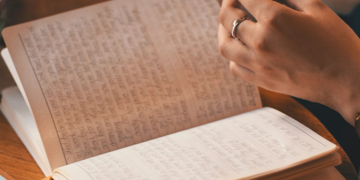 A person calmly writing notes in a journal or notebook, reflecting on their thoughts and experiences.
