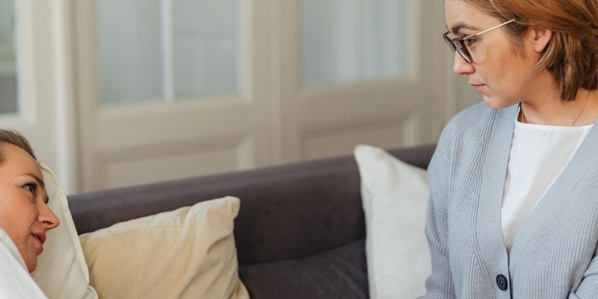 A scene depicting a therapist and client engaged in a calm and supportive conversation during a therapy session.