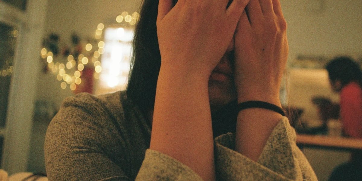 A person sitting quietly, displaying expressions of anxiety or feeling overwhelmed, conveying the internal struggle of panic.