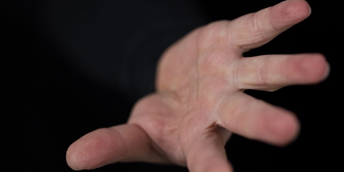 A person extending a hand, symbolizing seeking help or accepting support from others during a challenging time.