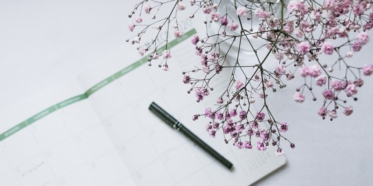 A person using a planner or app to track their menstrual cycle, a key habit for long-term menstrual health and awareness.
